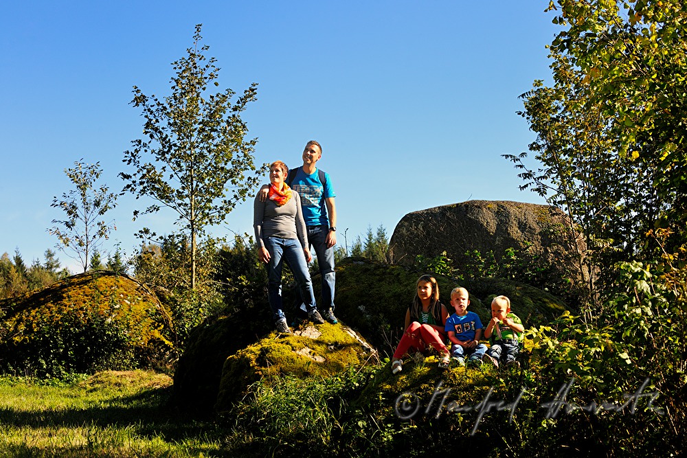 Familie macht eine Pause beim Granitblock