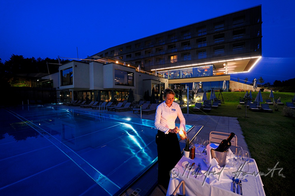 Kellnerin deckt einen Tisch neben dem Pool