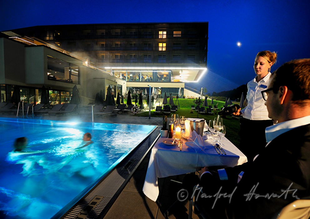 Kellnerin deckt einen Tisch neben dem Pool