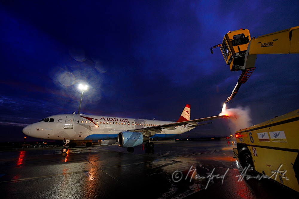 Enteisung der Tragflächen vor dem Start des Flugzeuges
