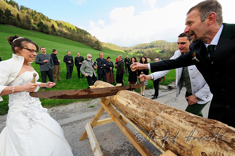 Brautpaar muss auf dem Weg zur Kirche Holz durchsägen