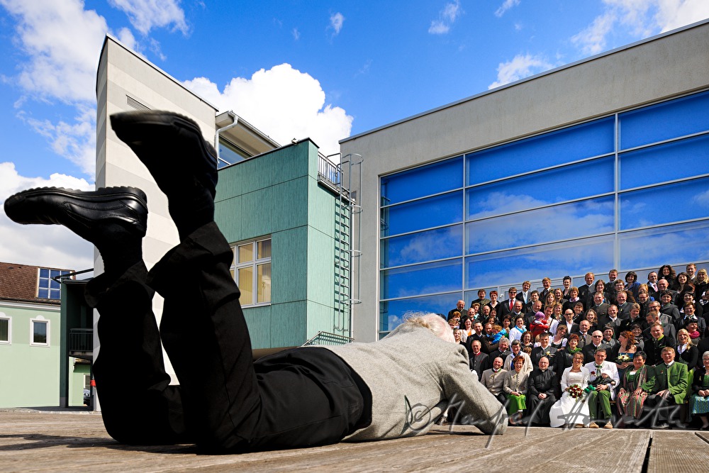 Fotograf liegt auf dem Boden für ein Gruppenfoto