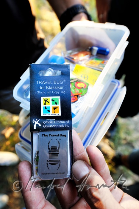 GPS-Gerät und Geocache beim Ort des Versteckes
