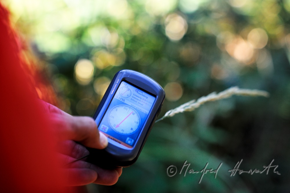 GPS-Gerät und Geocache beim Ort des Versteckes
