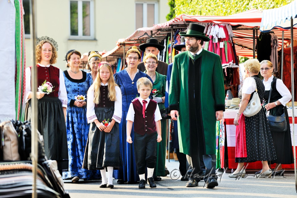 Gruppe von Mostviertlern in Tracht am Jahrmarkt