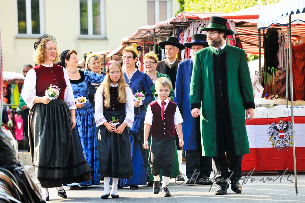 Gruppe von Mostviertlern in Tracht am Jahrmarkt