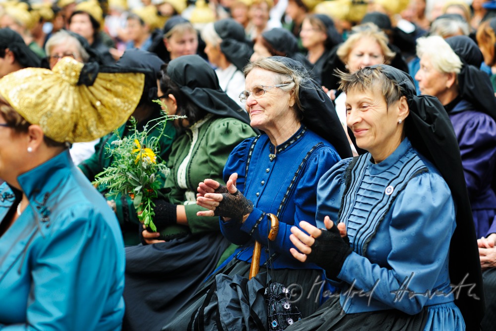 Besucher der Messe in traditioneller Tracht