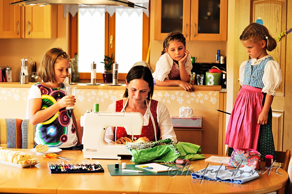 Mutter beim Schneidern eines Kinder-Dirndls