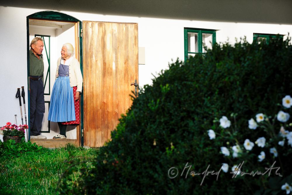 Frau Fuchs gießt die Blumen vor ihrem Bauernhaus