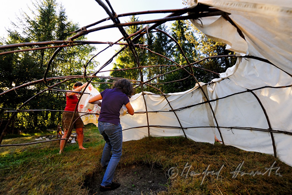 Aufbauen der Schwitzhütte aus Holzstäben und Decken