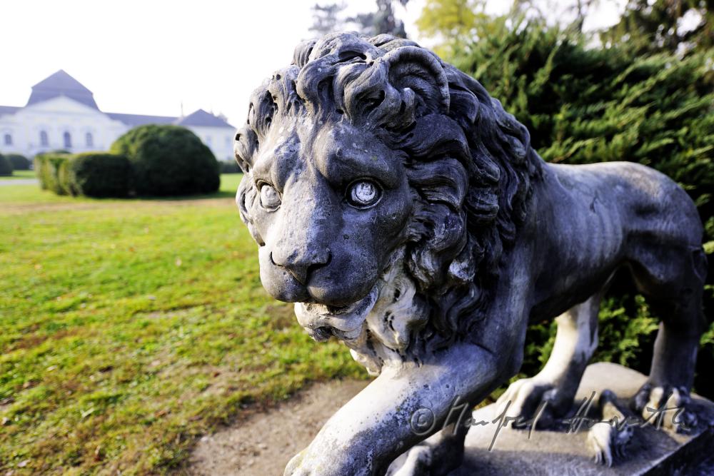 Skulptur eines Löwen und Gartenfront