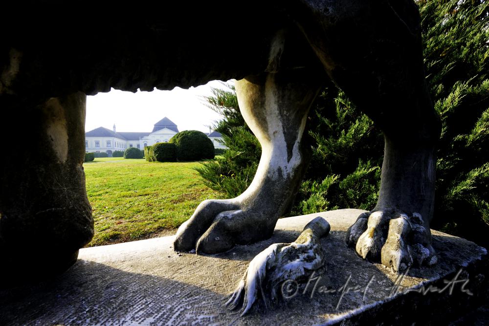 Skulptur eines Löwen und Gartenfront