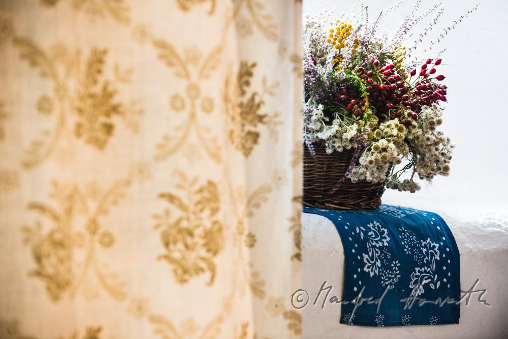 Blaudruck-Tuch und Trockenblume an einem Fenster