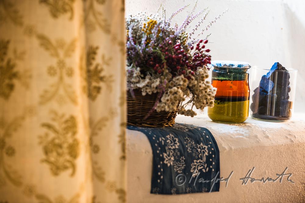 Blaudruck-Tuch und Trockenblume an einem Fenster