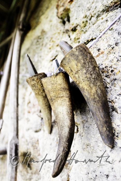 Köcher für Sensen-Wetzsteine aus Horn hängen an der Scheunenmauer