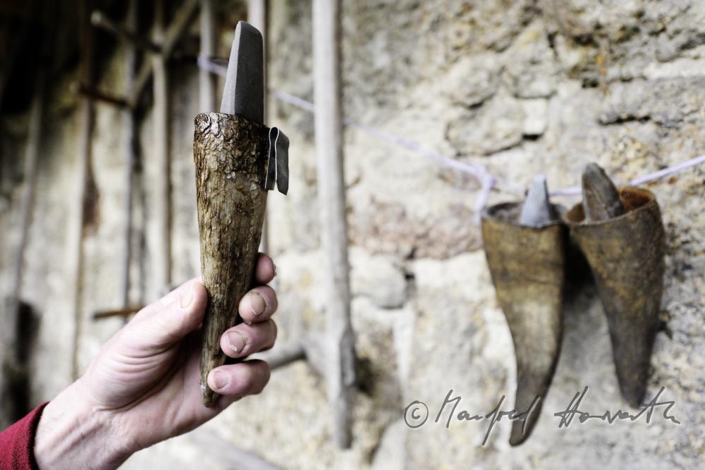Köcher für Sensen-Wetzsteine aus Horn hängen an der Scheunenmauer