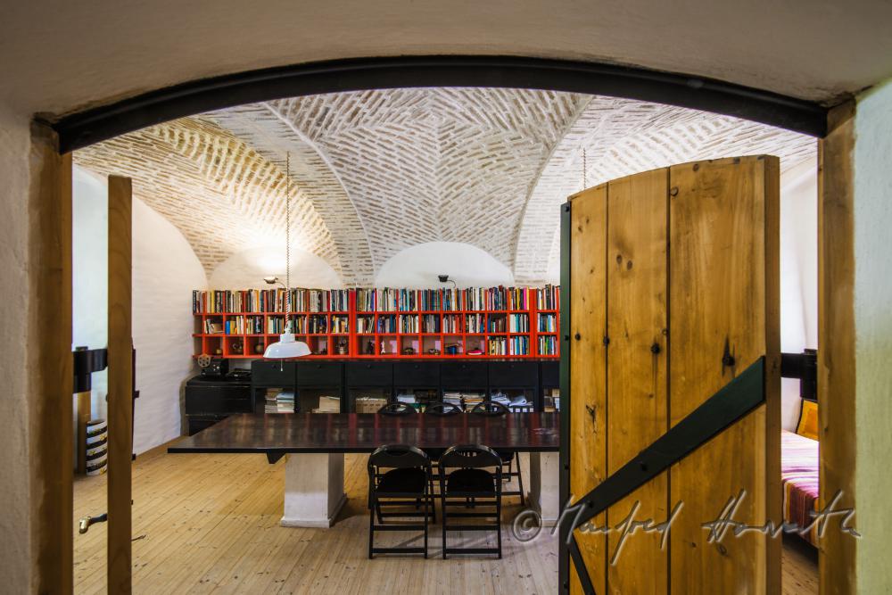 Bibliothek und Arbeitstisch unter Ziegelgewölbe