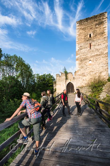 Burg Kaja und Wanderer auf der Holzbrücke