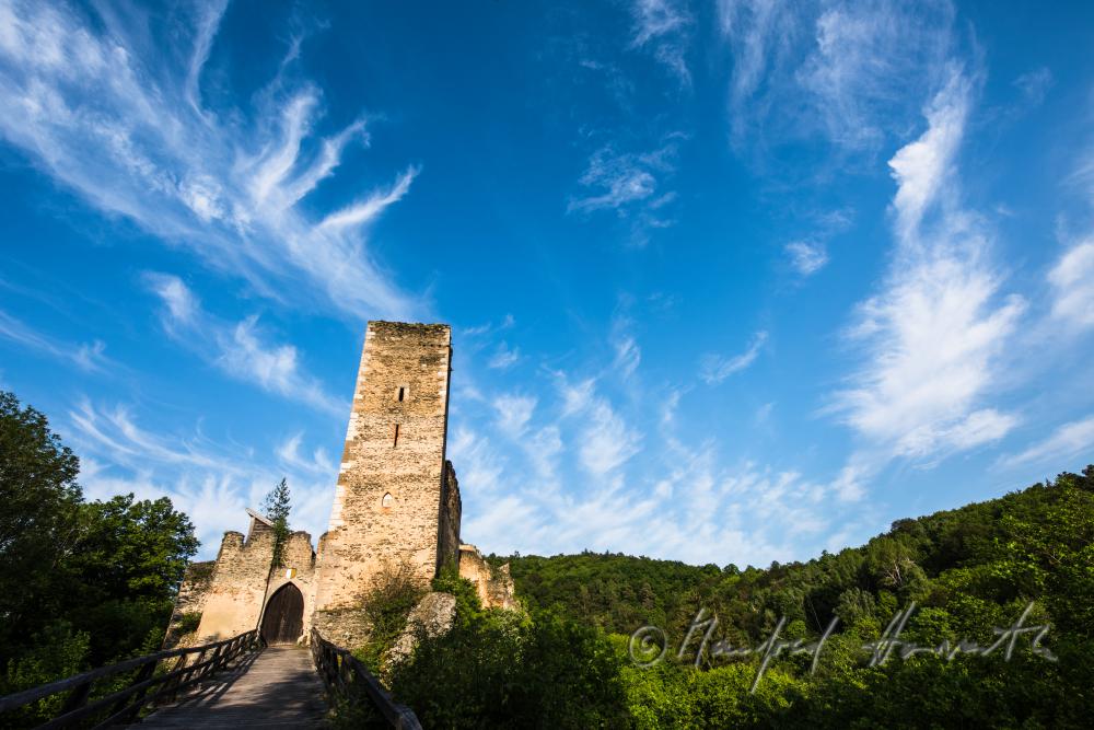 Burg Kaja und Wanderer auf der Holzbrücke