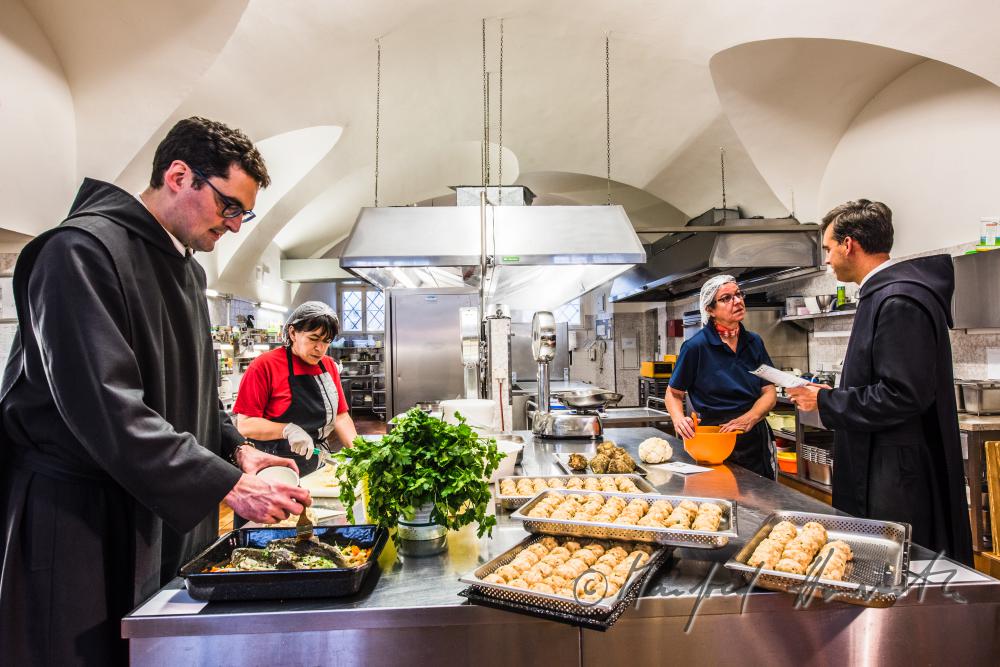 Küchenchefin und Mönche kochen in der Klosterküche