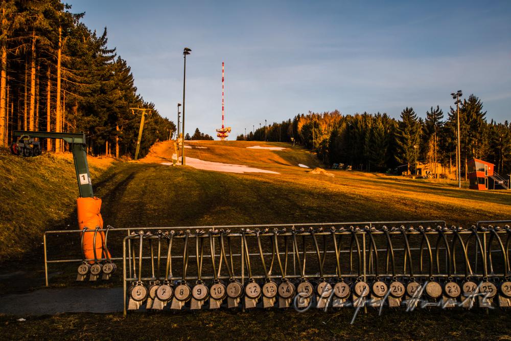 Skilift und Skipiste mit Schneeresten im Frühling